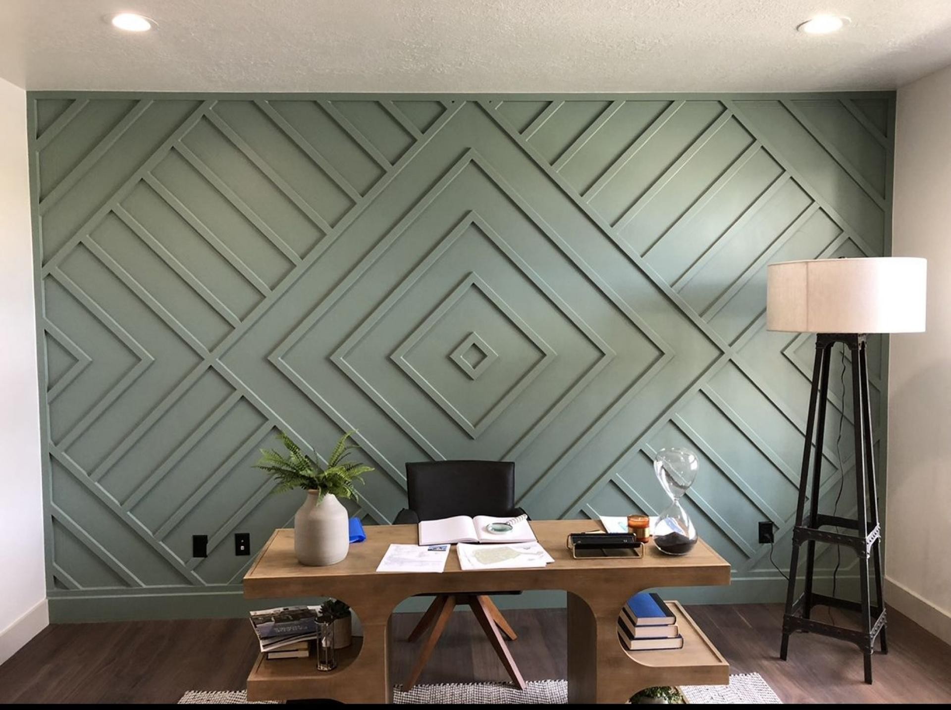 Interno di un ufficio moderno con boiserie geometrica verde salvia realizzata con modanature in poliuretano Polure.