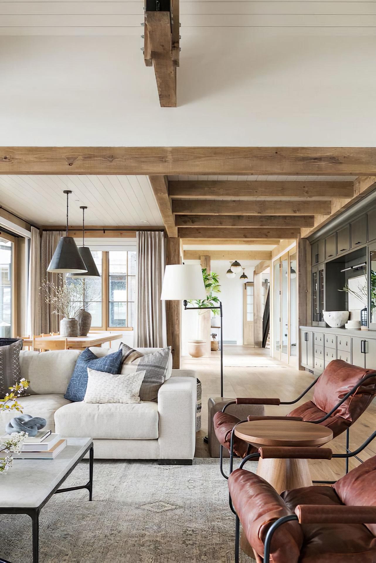 Soggiorno moderno con travi e correnti Polure in poliuretano effetto legno su soffitto alto con texture rustiche.