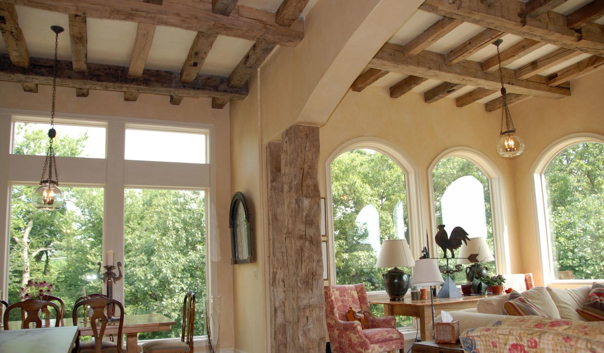 Soggiorno rustico con travi in poliuretano Polure P1981H e tronchi decorativi effetto legno per soffitti a griglia.