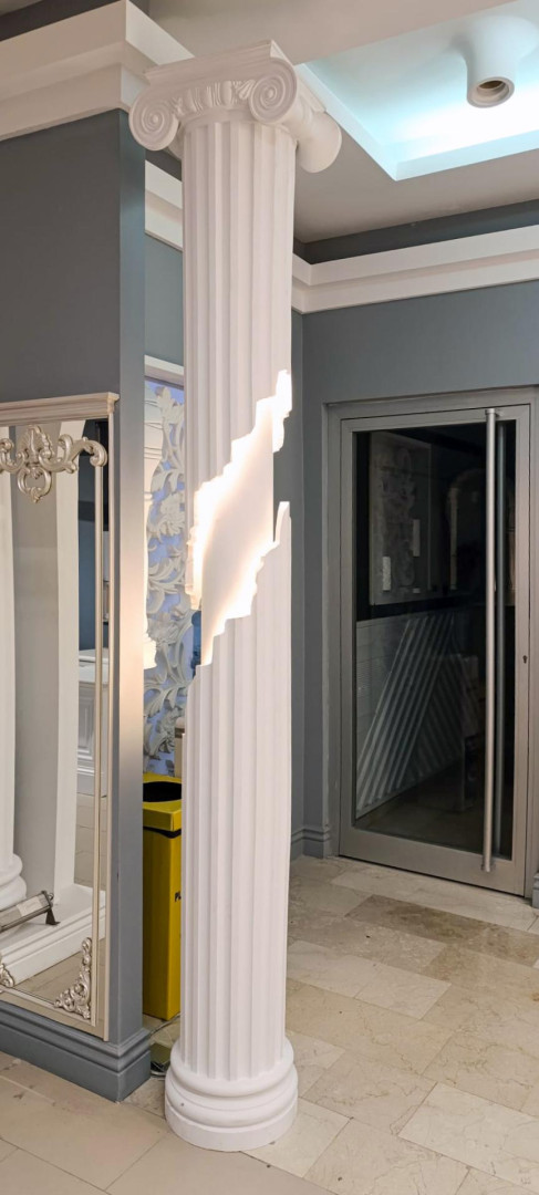 Interno moderno con colonna ionica Polure in poliuretano illuminata, capitello P5930B e fusto segmentato P5230I.
