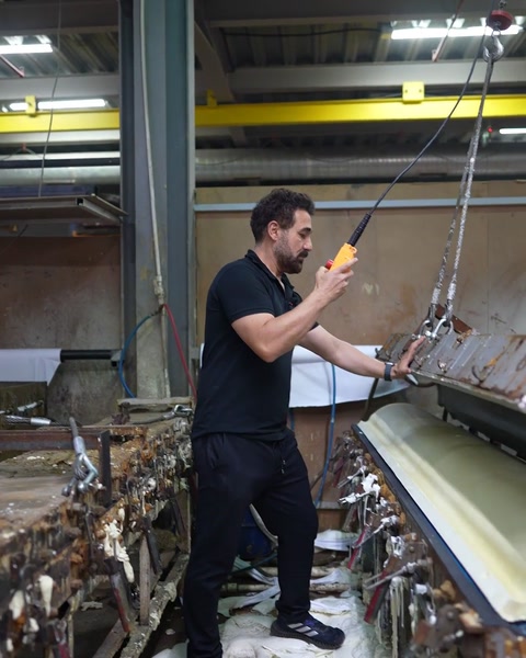 Operator guides crane pendant to raise upper half of aluminium mould