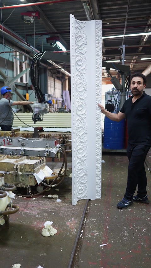 Full length cornice standing upright next to production benches
