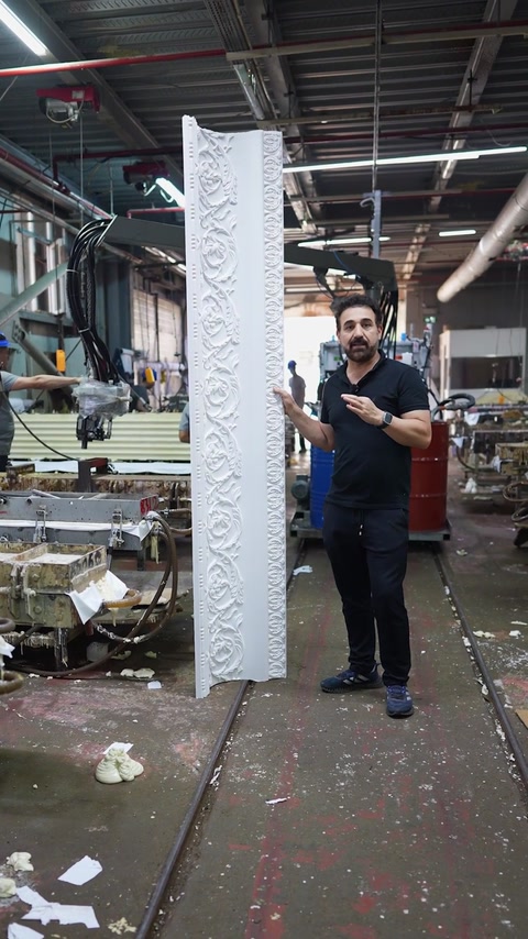 Presenter shows complete patterned cornice length on factory floor