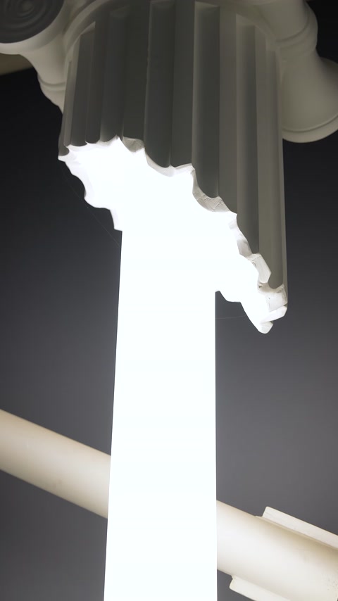 Close-up view of the illuminated decorative surface beneath a column capital