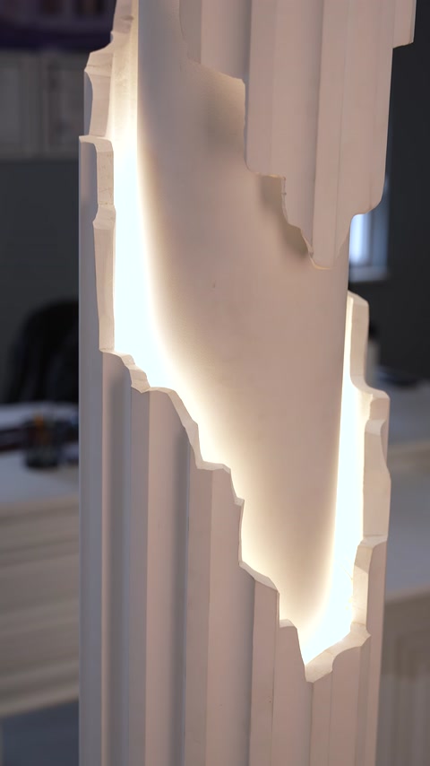 Layered column cladding detail emphasized by concealed LED lighting