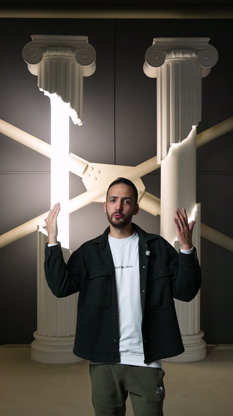 Presenter shows lighting design between two decorative columns