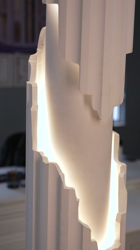 Wavy plexiglass strip on column surface highlighted with warm lighting