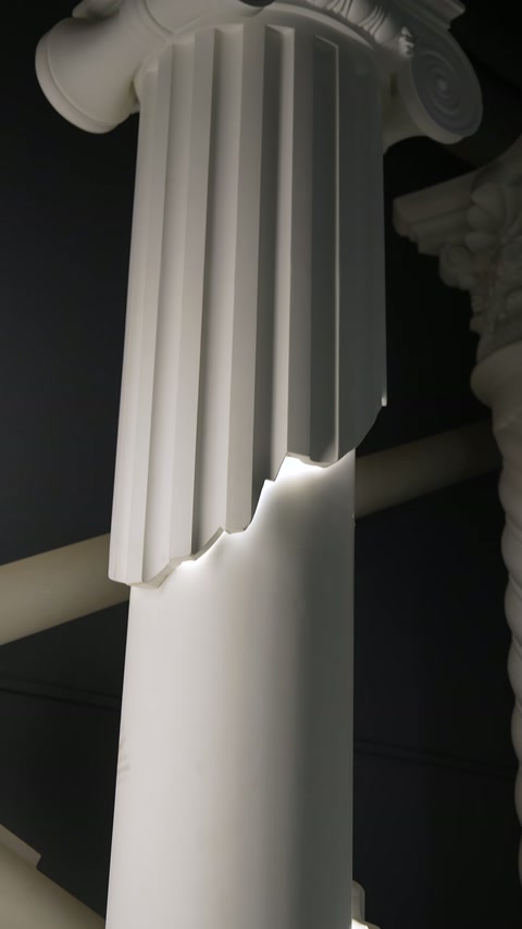 Flutes beneath classical capital meet cross-lit section