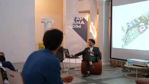 Sunum salonunda konuşmacı, mimarlık öğrencilerine proje anlatıyor