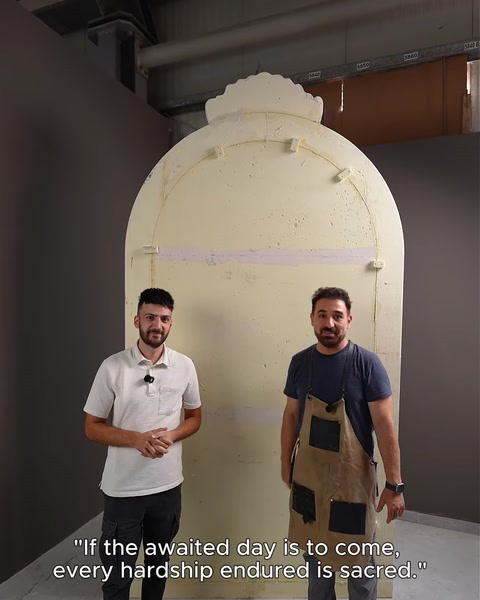 Two craftsmen inspect a raw unfinished arch mould before finishing.