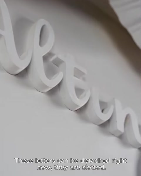 Close-up of slotted boutique-name letters lifted from their groove channel.