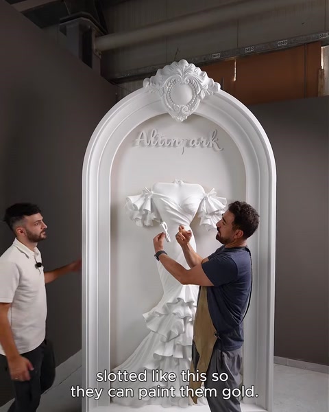 Two men detaching the grooved lettering from the arch relief panel.