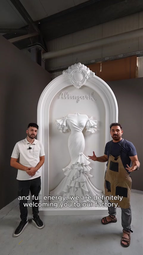 Due artigiani in piedi accanto all'arco personalizzato finito in fabbrica.