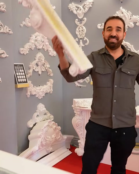 Uomo che solleva un lungo pezzo di capitello accanto a un'esposizione di mantello del camino