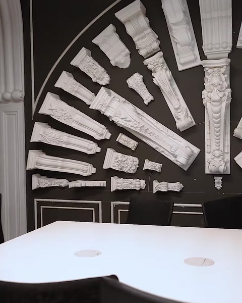 Esposizione murale che mostra dozzine di capitelli in poliuretano di varie dimensioni