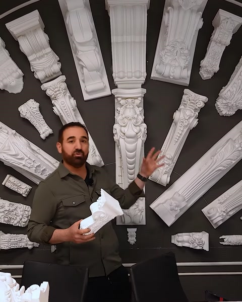 Uomo che tiene un piccolo capitello mentre spiega l'applicazione decorativa