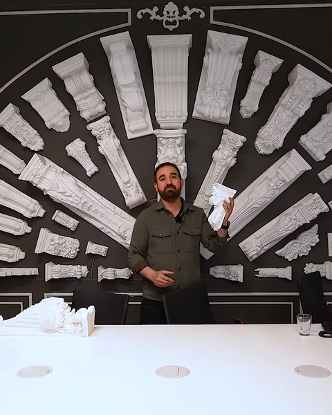 Uomo che si trova accanto a un tavolo con esposizione di capitello e muro di colonne
