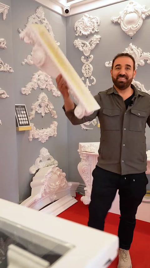 Uomo che solleva un lungo pezzo di capitello accanto a un'esposizione di mantello del camino
