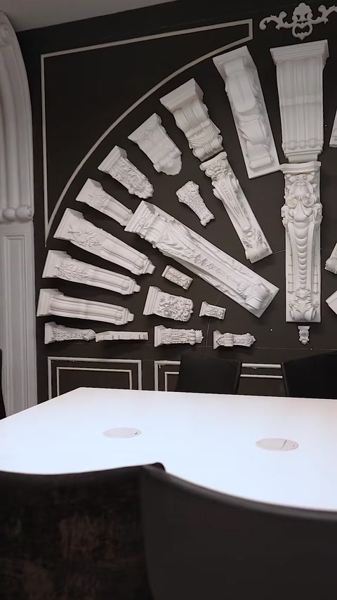 Esposizione murale che mostra dozzine di capitelli in poliuretano di varie dimensioni
