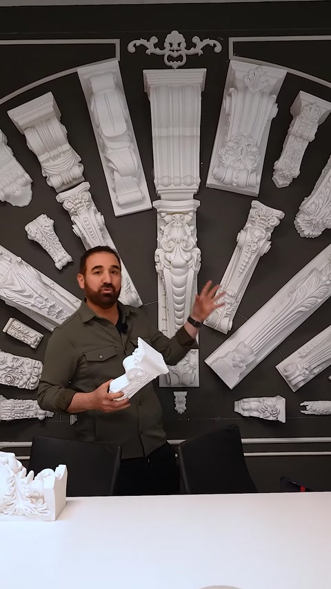 Uomo che tiene un piccolo capitello mentre spiega l'applicazione decorativa