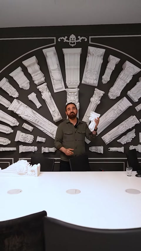 Uomo che si trova accanto a un tavolo con esposizione di capitello e muro di colonne