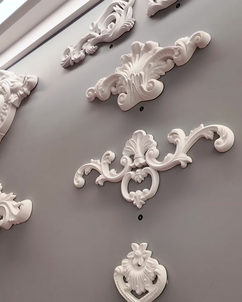Applique murali decorative a motivi floreali e a voluta esposte