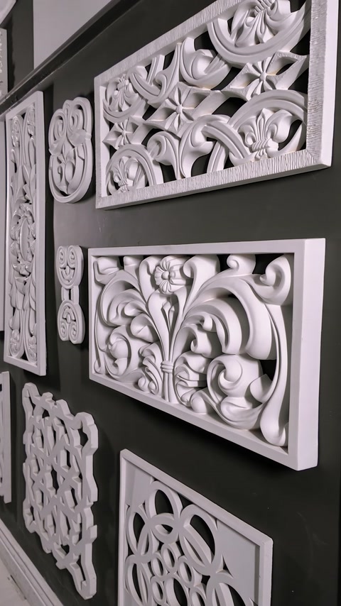 Two ornate relief wall panels displayed side by side on dark wall