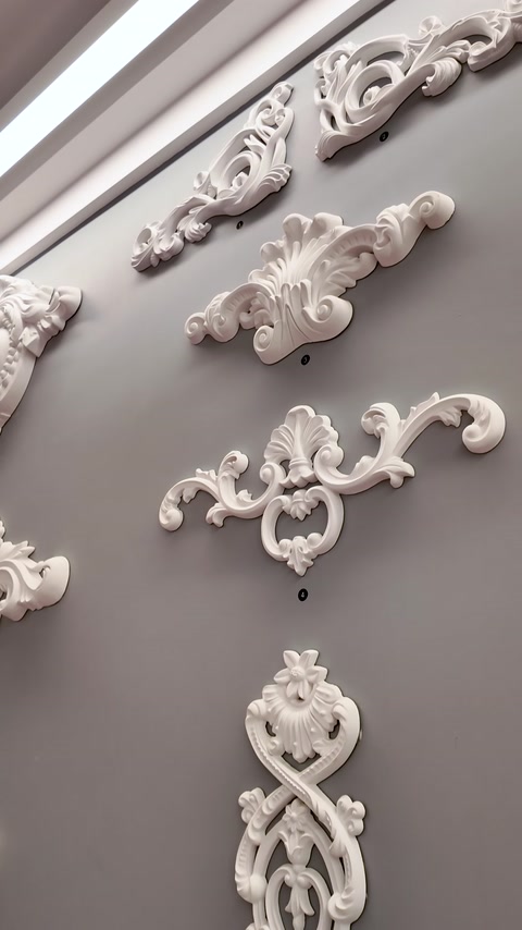 Decorative scroll and floral wall appliques mounted for display