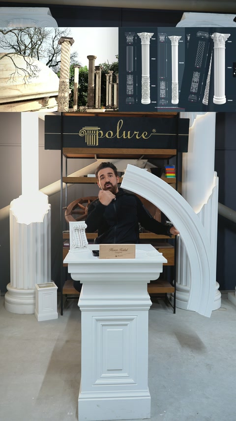 Il presentatore espone un esempio di cornice tra le colonne decorative della showroom