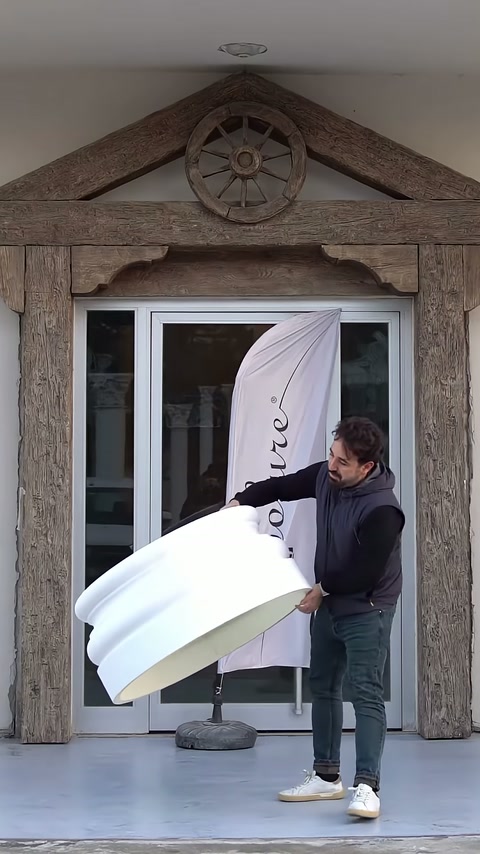 L'artigiano ruota la base dal profilo arrotondato davanti all'ingresso mostrandola