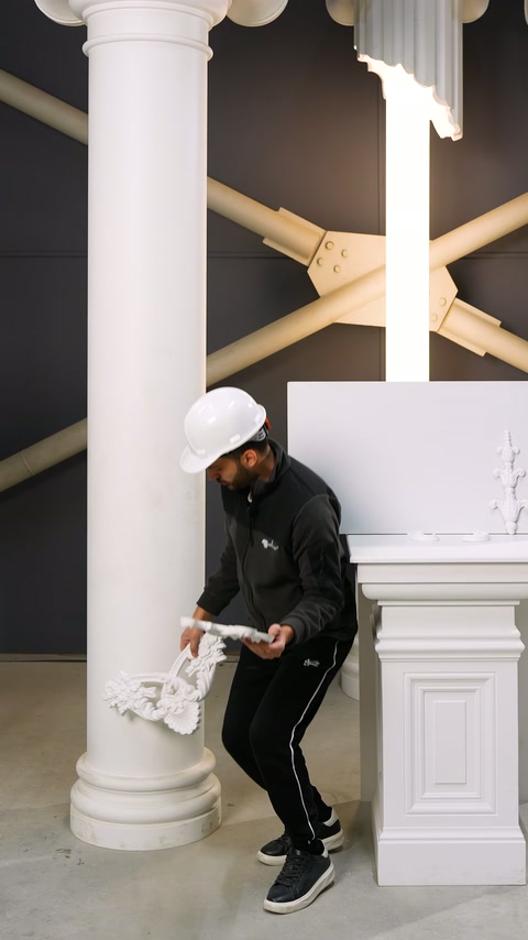 Applicatore prepara l'elemento ornamentale accanto alla base della colonna per l'installazione