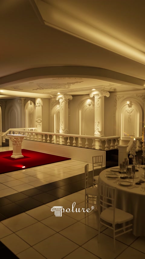 Angolo della sala illuminata con fila di colonne e balaustra decorativa che si estende