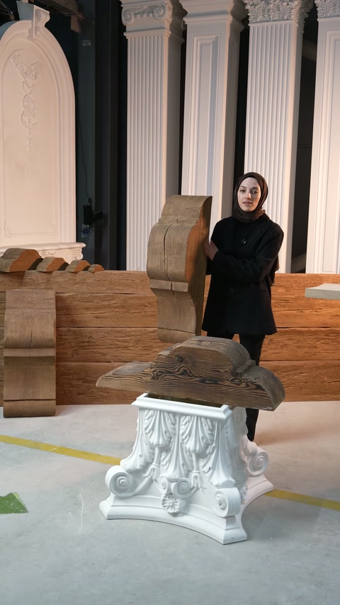 Una grande cornice decorativa è esposta verticalmente tra diversi modelli nella showroom.