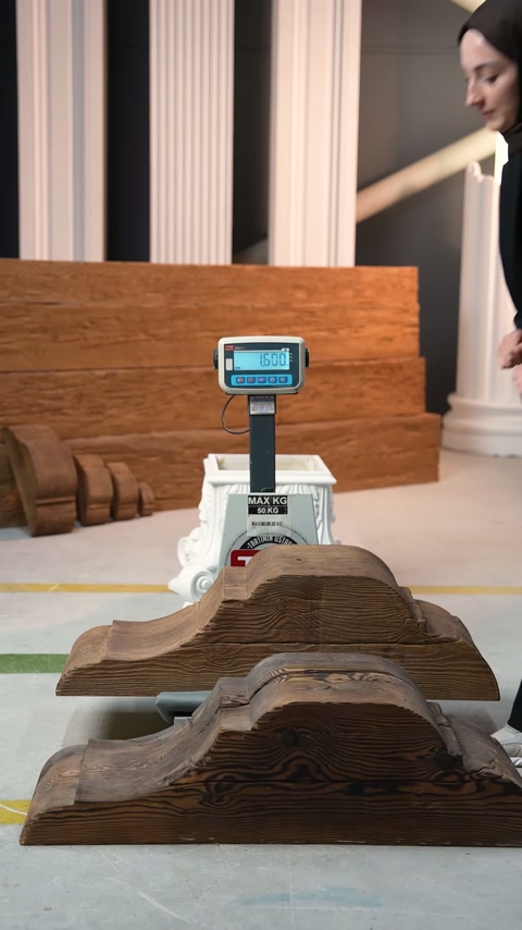 Due cornici con pattern in legno sono allineate davanti alla bilancia digitale.