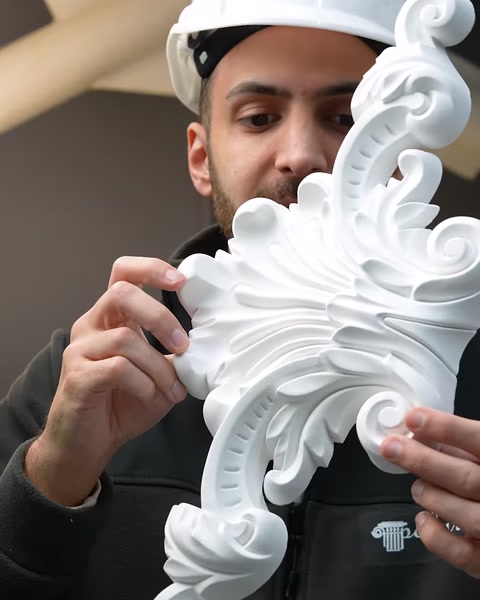 Büyük akantus motifli poliüretan süs parçası yakından inceleniyor.