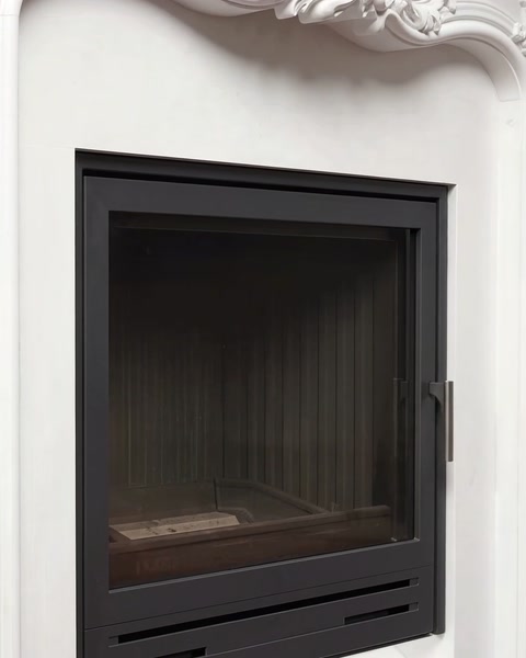 Close view of the firebox framed by a white decorative surround