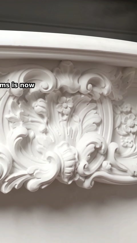 Symmetrical leaves and blossoms form the mantel's central decorative relief.