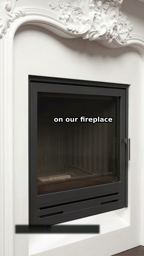 The black firebox sits beneath an arched opening with floral decoration.
