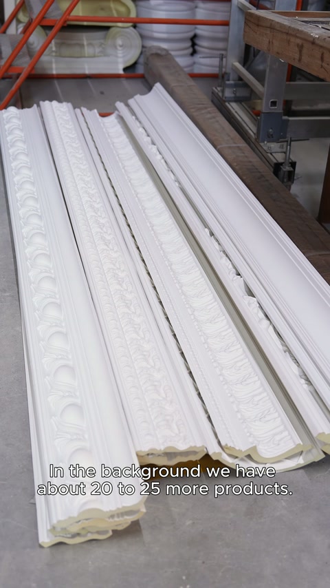 Long cornice profiles arranged together on work table in workshop
