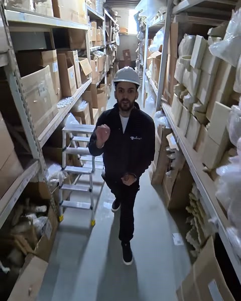 Employee walks through warehouse aisle stocked with boxed moldings