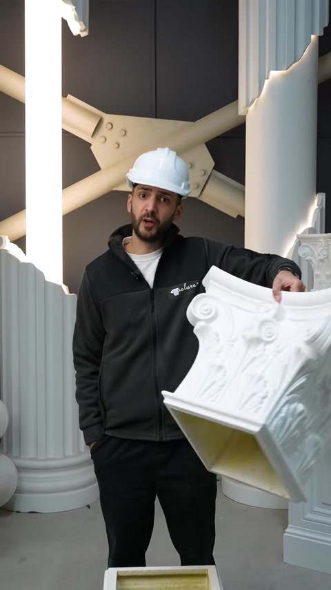 Employee presents white polyurethane cornice molding near columns