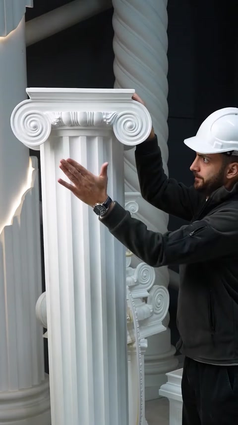 Staff member gestures beside tall fluted Ionic polyurethane column
