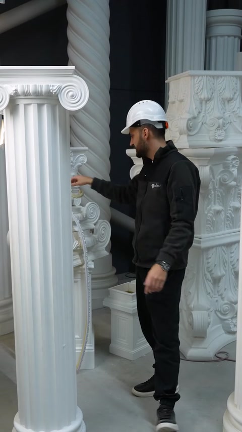 Employee examines carved capital detail on polyurethane column