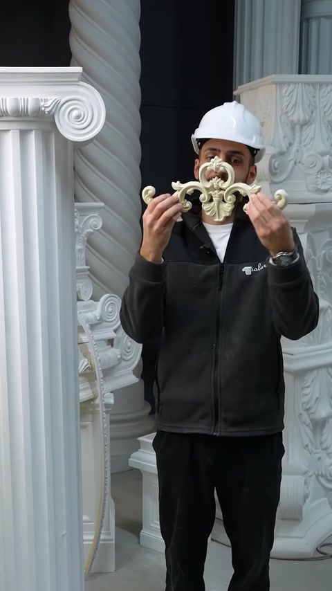 Employee holds ornate polyurethane acanthus scroll applique piece