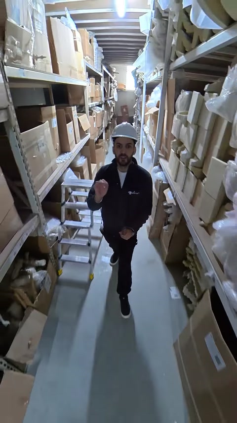 Employee walks through warehouse aisle stocked with boxed moldings