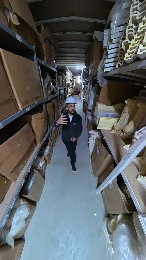 Employee speaks to camera walking through polyurethane storage warehouse