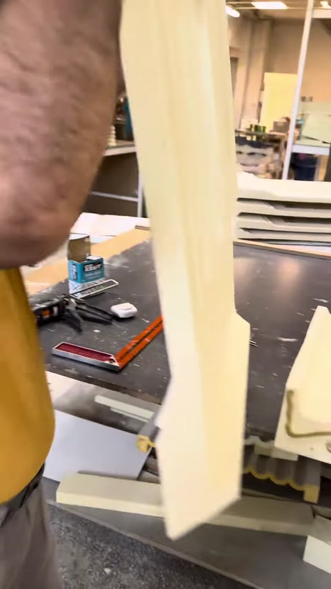 The long polyurethane profile is checked vertically before assembly