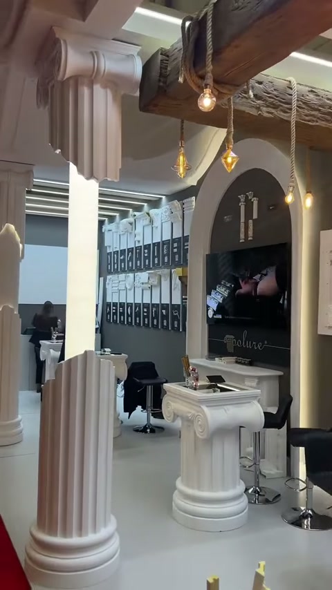 Fluted columns, wooden ceiling beams and pendant lamps surround the stand