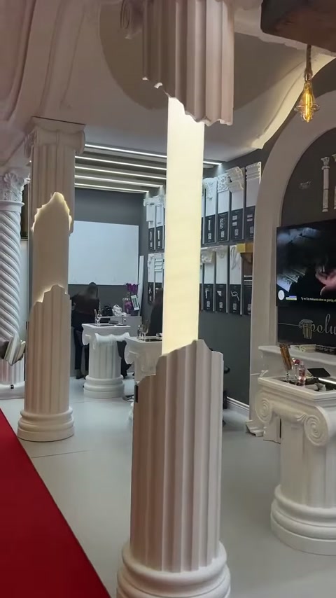 Tall columns and capital-shaped display table stand out in the fair area