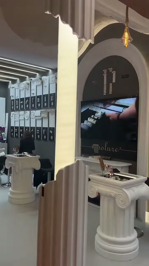 Fluted display elements, antique-topped table and wall panels are shown